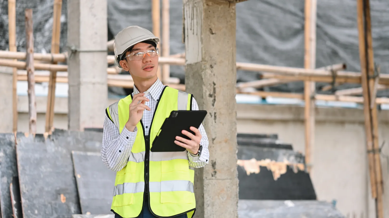 Inspector ambiental con tablet revisando documentación en una planta industrial